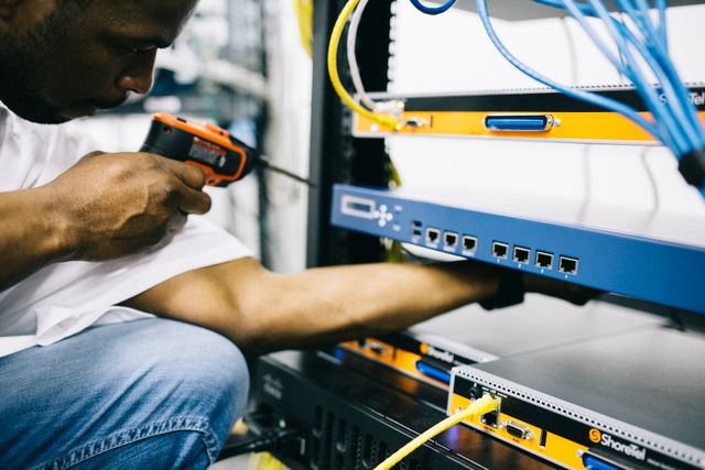 A CableOne technician installing a router and set-top box in a living room